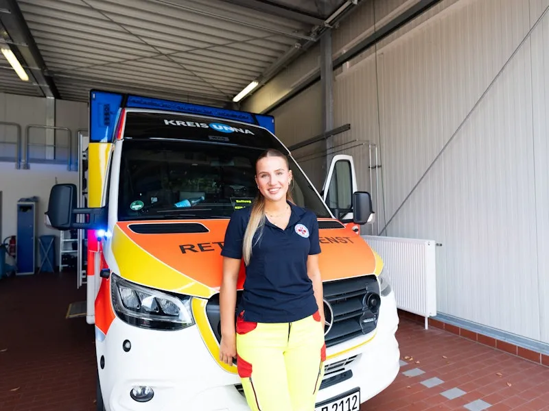 Woman standing in front of an ambulance.