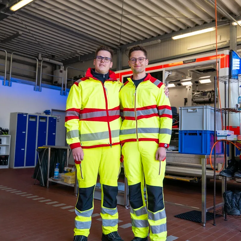 Zwei Männer die vor einem Rettungswagen stehen.