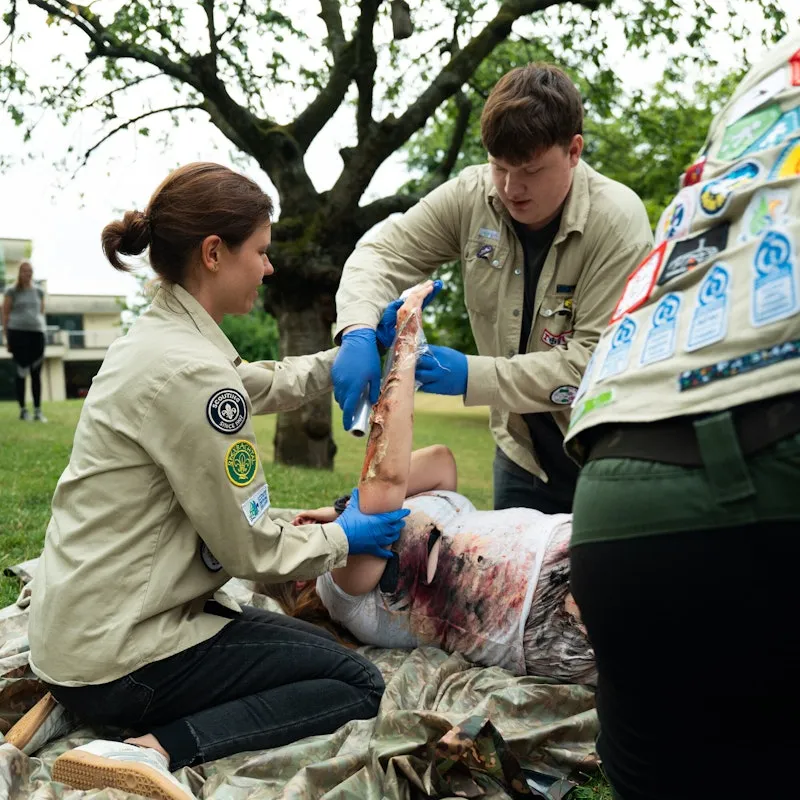 People outside participating in a first aid workshop.